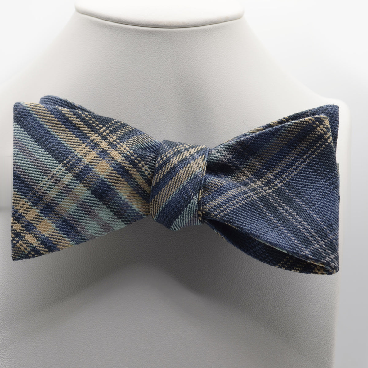 Blue and Sage Plaid Bow Tie shown on a white display stand