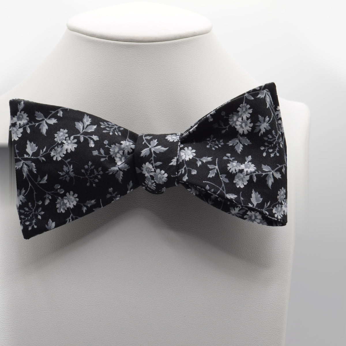 Black and Silver Floral Bow Tie shown on a white display stand