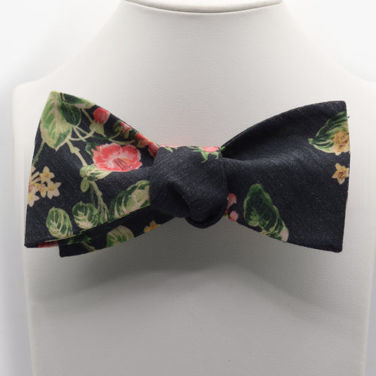 Black Floral Bow Tie shown on a white display stand