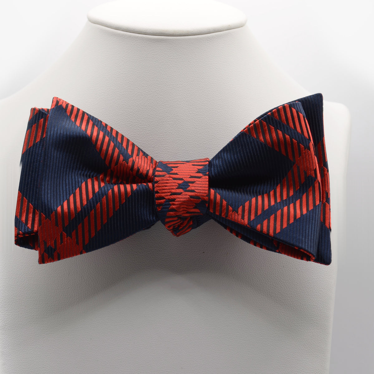 Navy and Red Geometric Bow Tie shown on a white display stand