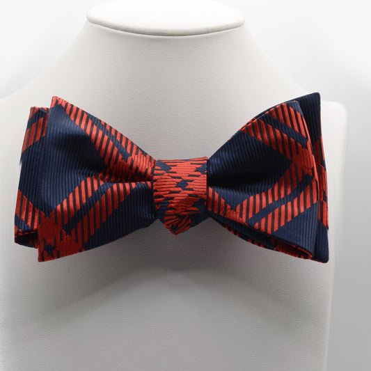 Navy and Red Geometric Bow Tie shown on a white display stand