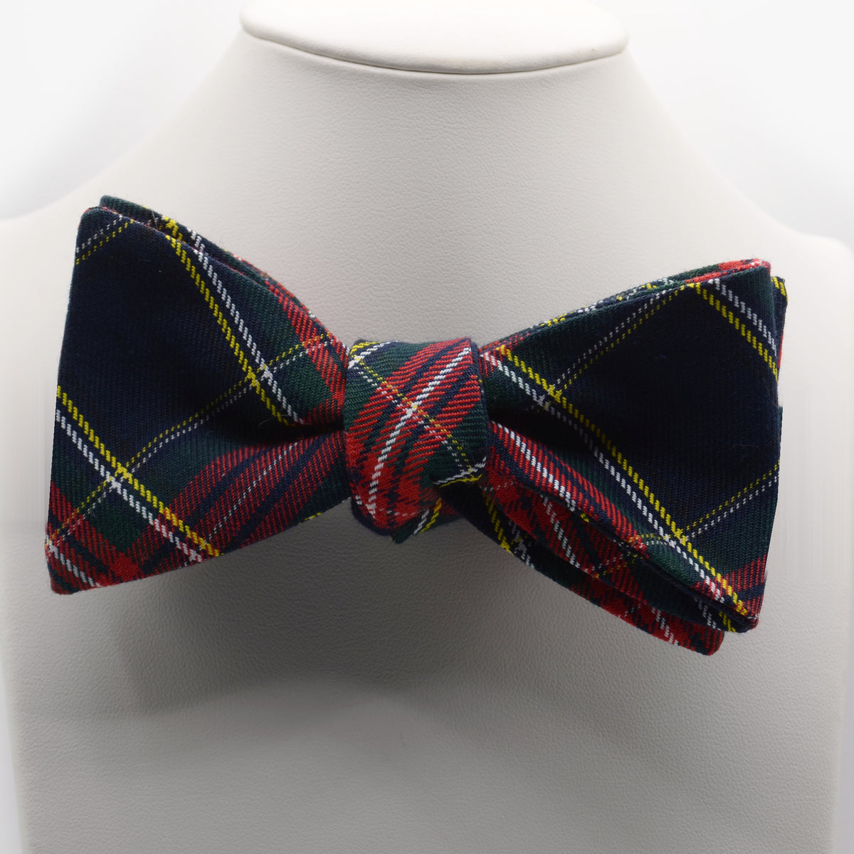 Navy Tartan Bow Tie shown on a white display stand
