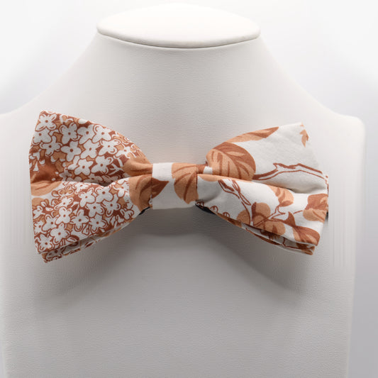 Orange and Cream Floral Bow Tie shown on a white display stand