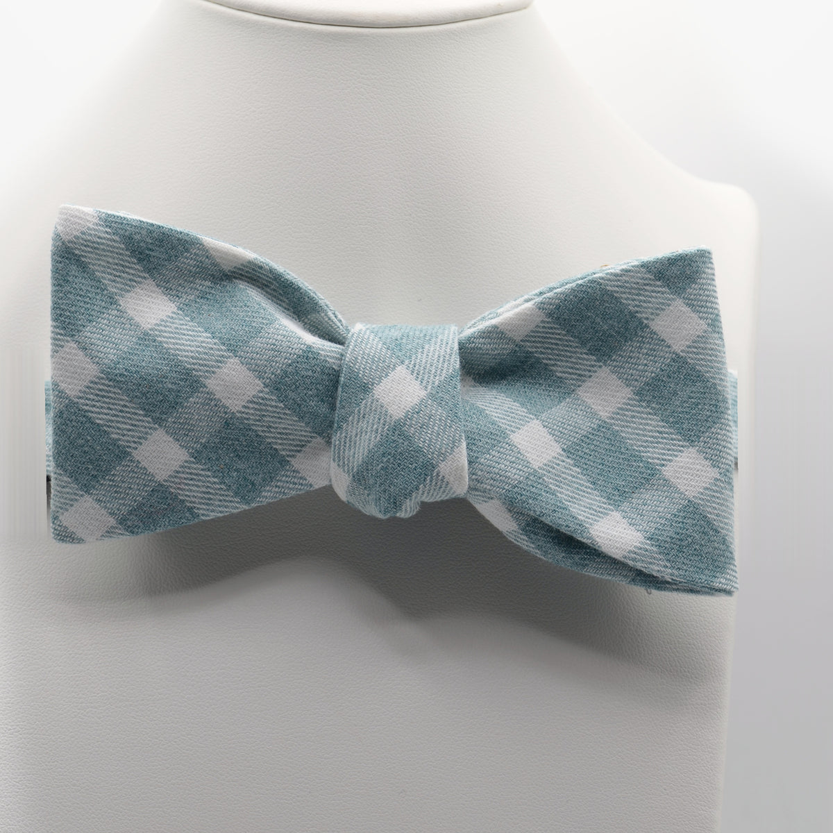 Sage Blue Gingham Bow Tie shown on a white display stand